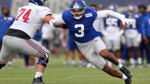 Abdul Carter pass rushing for the New York Giants in a blue No. 3 jersey