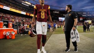 Marcus Mariota on the Washington Commanders sideline with a knee injury during preseason