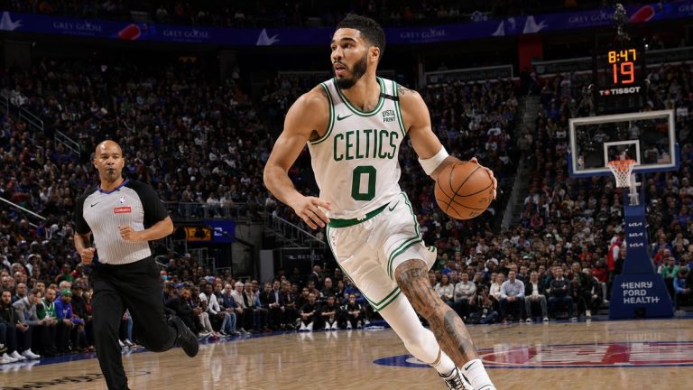Jayson Tatum of the Boston Celtics driving to the basket in a white road jersey during an NBA game in Detroit