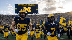 Michigan Wolverines football players in maize and blue uniforms on the field